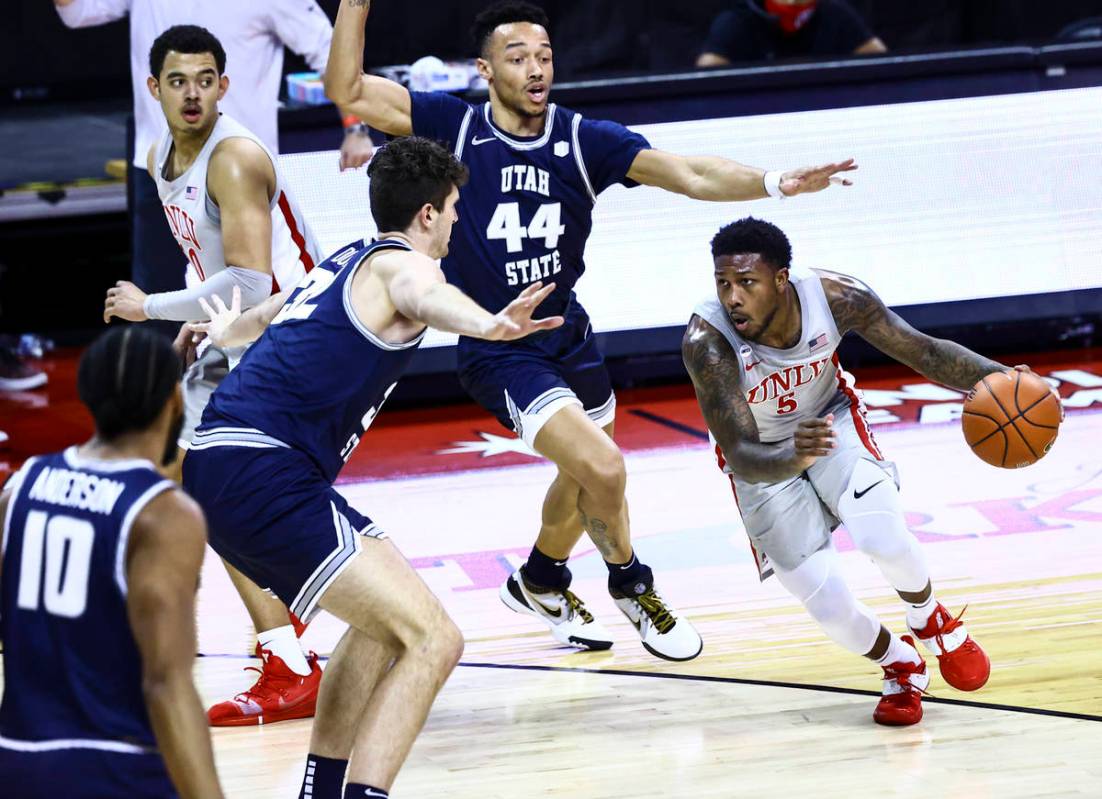 UNLV Rebels guard David Jenkins Jr. (5) drives against Utah State Aggies center Trevin Dorius ( ...