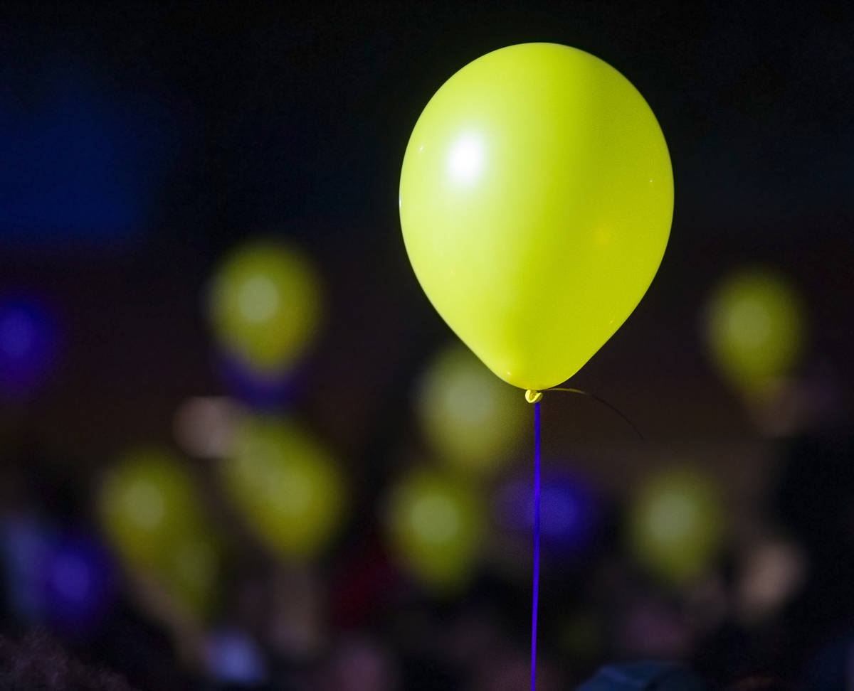 Fans hold balloons with Los Angeles Laker colors during a vigil for Kobe Bryant and daughter Gi ...
