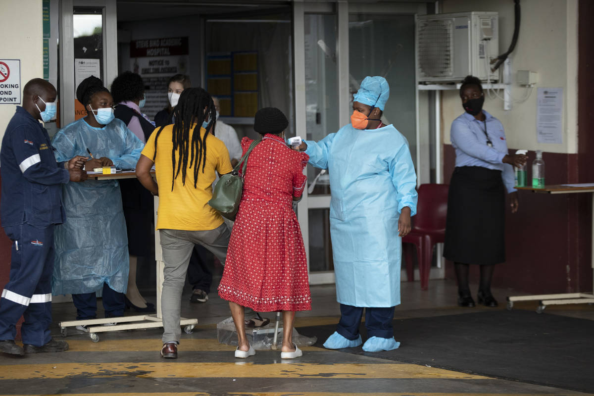 A health worker checks the temperature of an elderly patient at the emergency entrance of the S ...