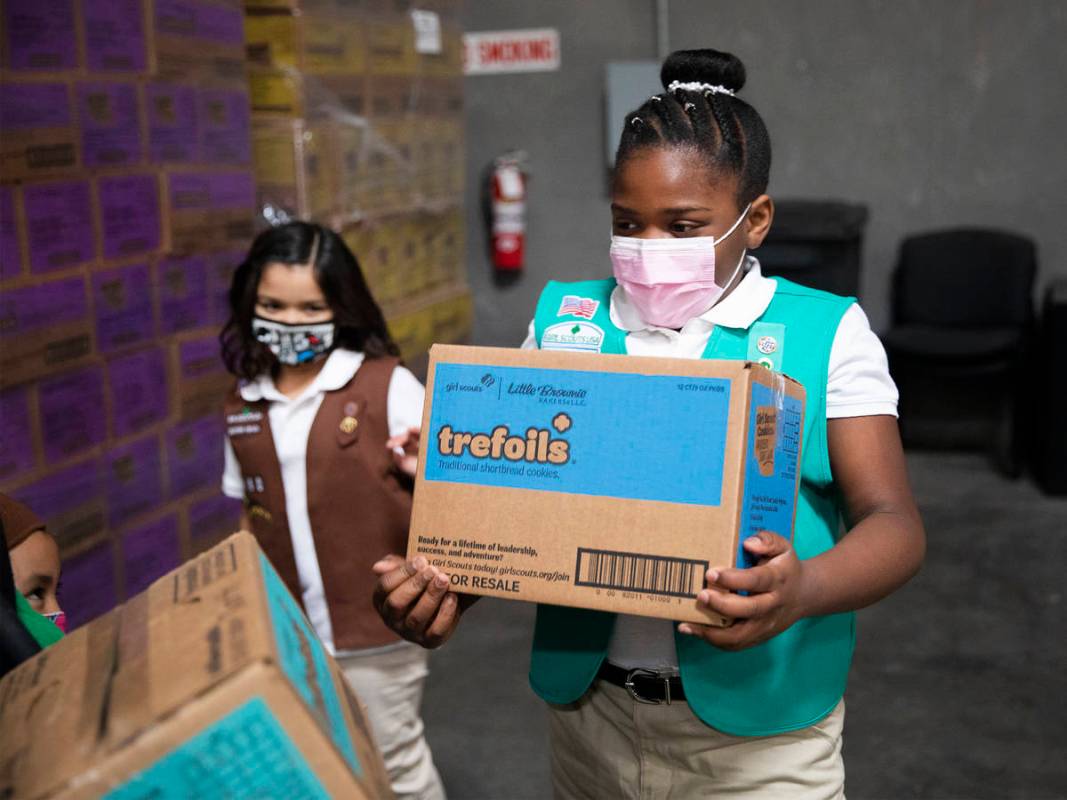 Girl Scout Aliyah H., 9, moves a box of Girl Scout Cookies at the Bekins Moving Solutions wareh ...