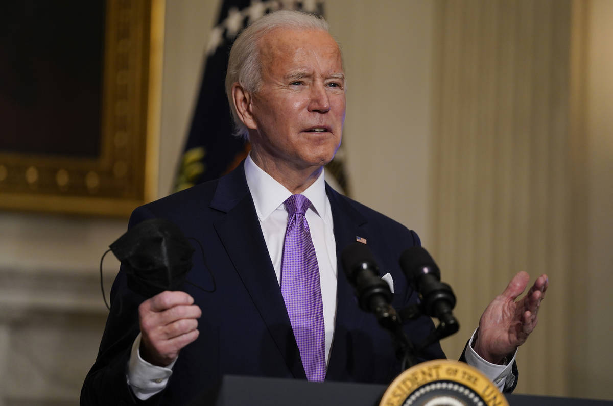 In a Jan. 26, 2021, photo, President Joe Biden holds his face mask as he speaks on COVID-19, in ...
