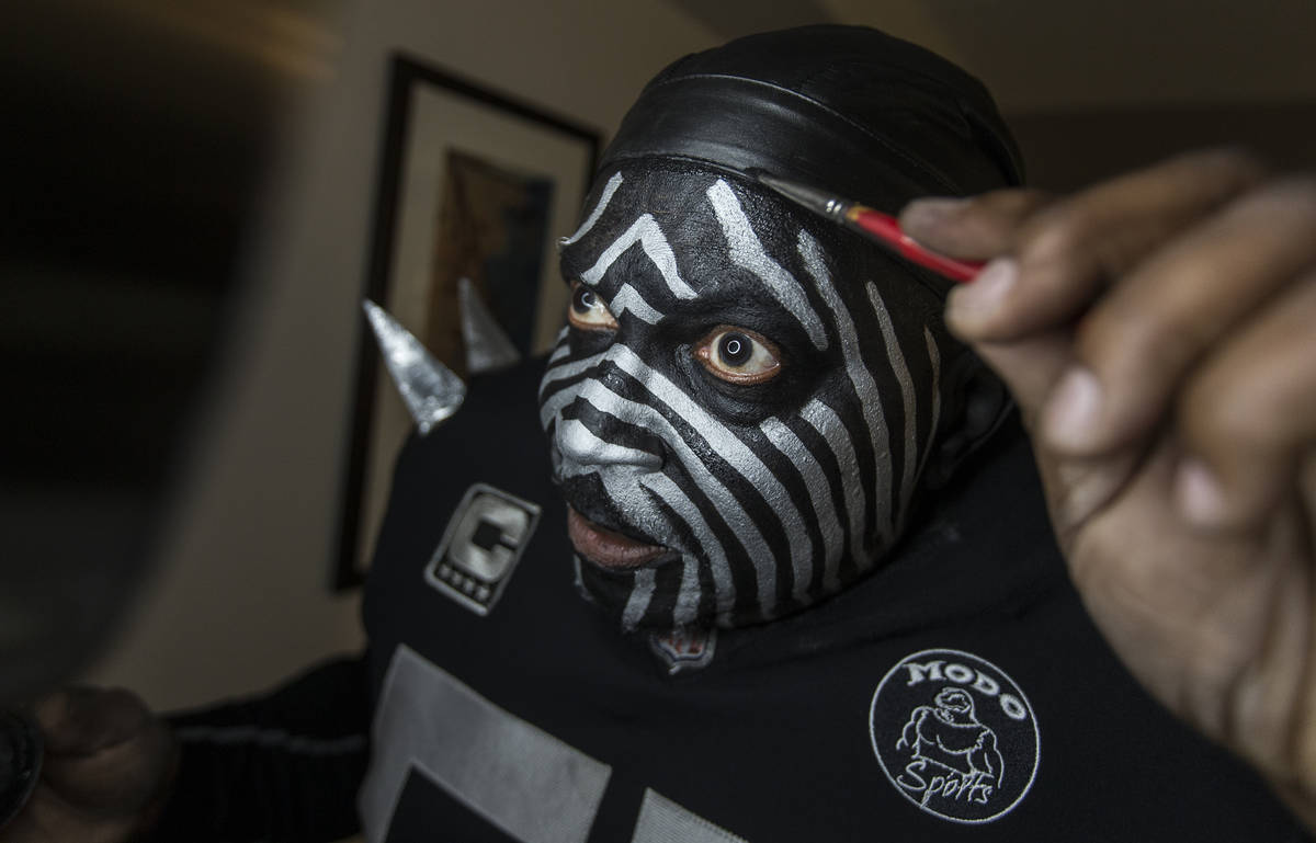 Raiders super fan Wayne Mabry, known as "Violator," applies makeup in his hotel room at 4 a.m. ...