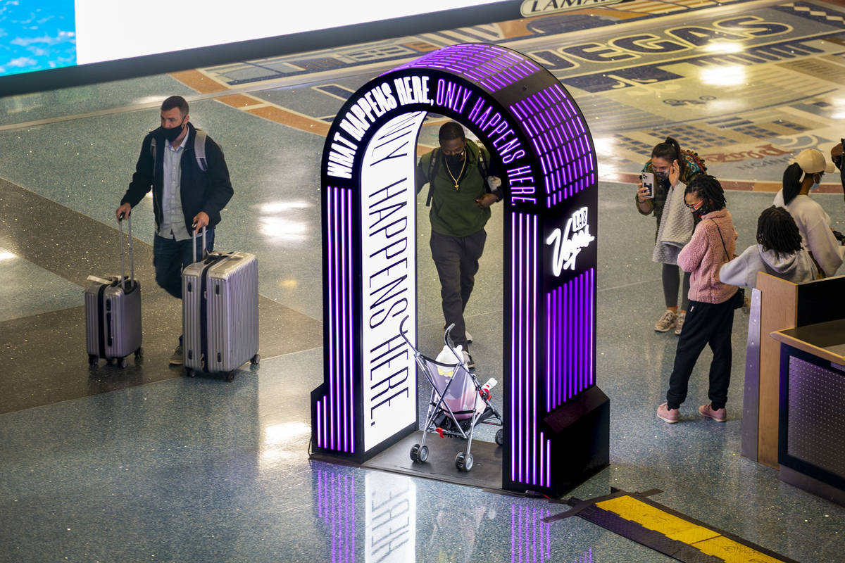 Visitors stop for a quick photo as arrivals continue at baggage in Terminal 1 during holiday tr ...