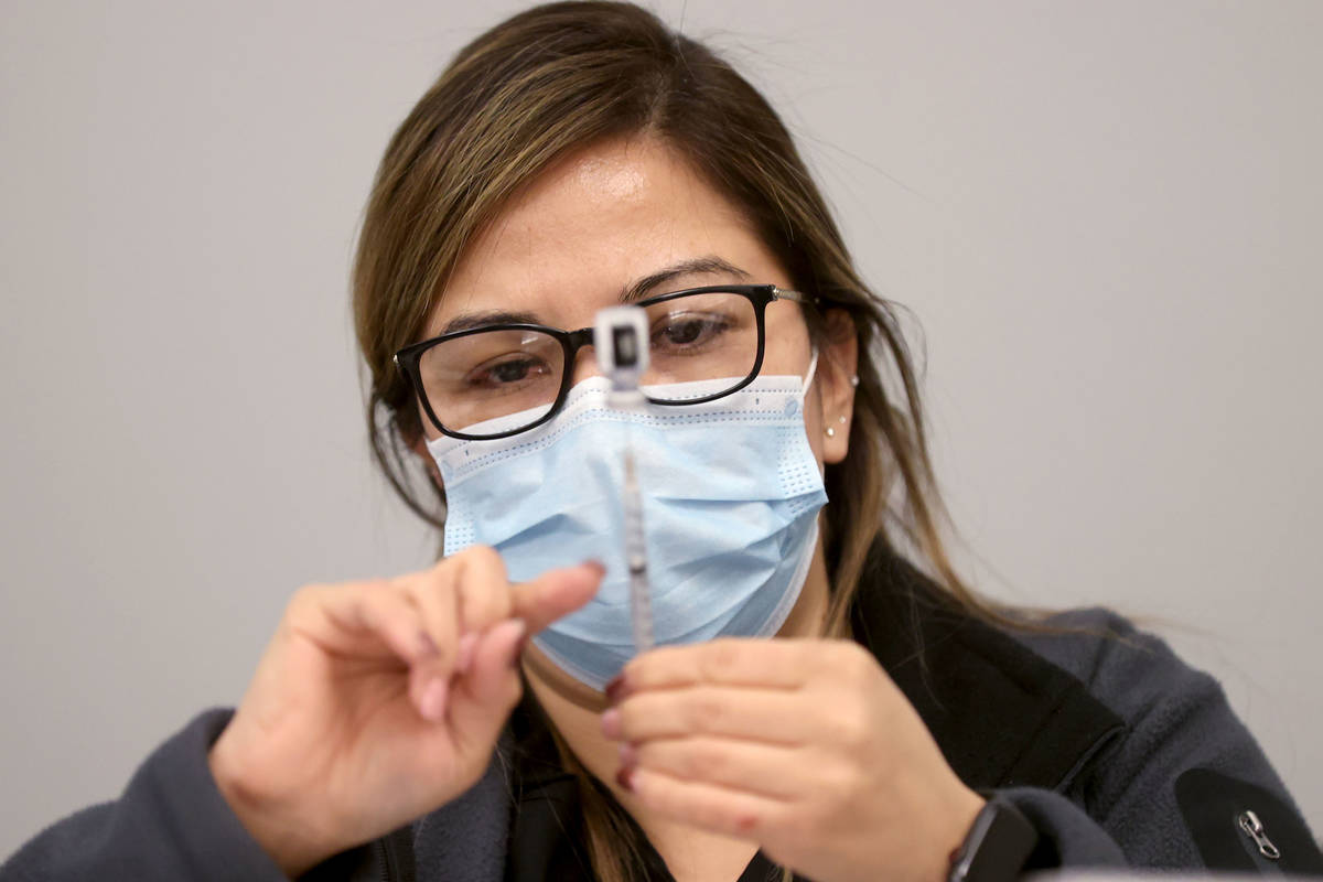 Certified Medical Assistant Martha Sida prepares a COVID-19 vaccine during a UNLV Medicine clin ...