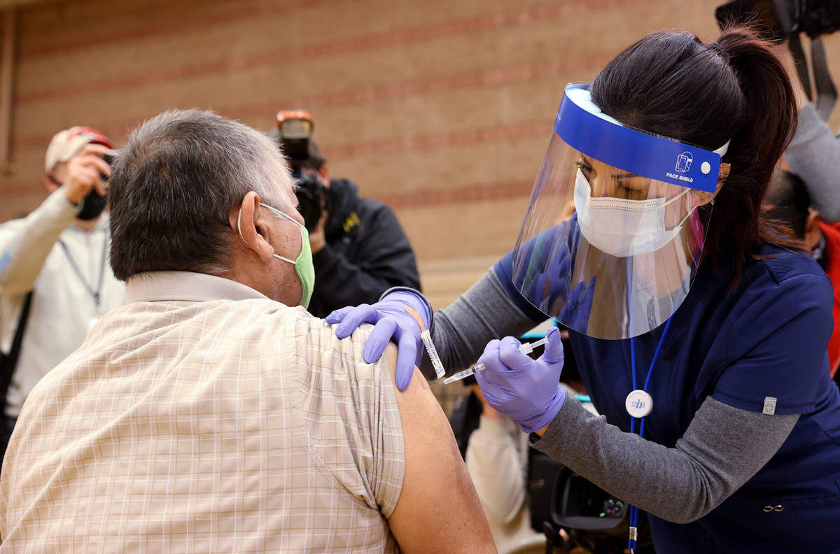 Daliah Rubio, a registered nurse with Southern Nevada Health District, vaccinates Victor Rodrig ...
