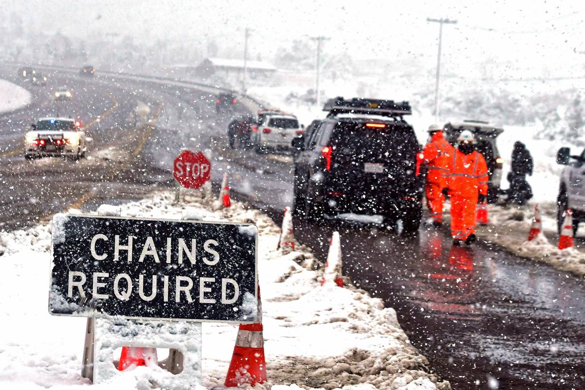 California Department of Transportation (Caltrans) employees check vehicles for chains at a man ...
