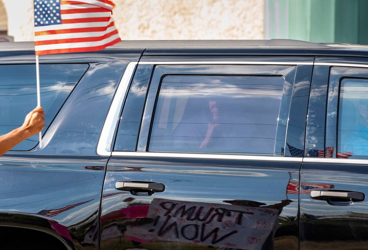 Former President Donald Trump passes supporters while traveling in his motorcade in West Palm B ...
