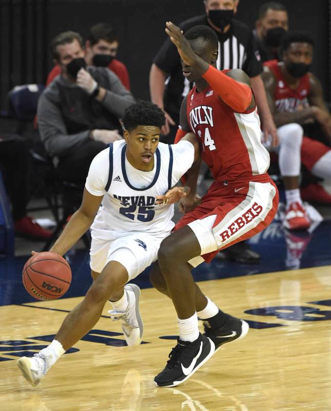 UNR's Grant Sherfield drives against UNLV's Cheikh Mbacke Diong in the first half of an NCAA co ...