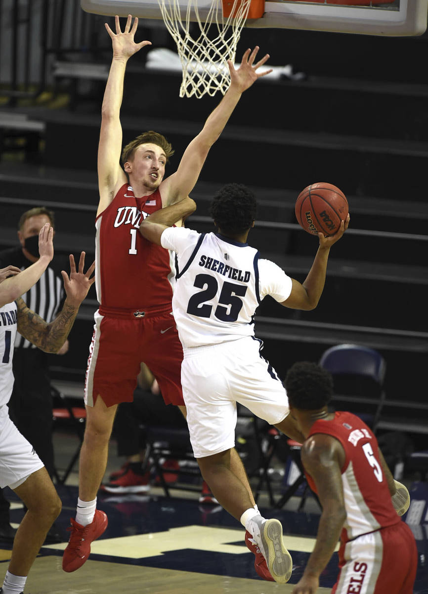 UNR's Grant Sherfield shoot against UNLV's Moses Wood in the first half of an NCAA college bask ...