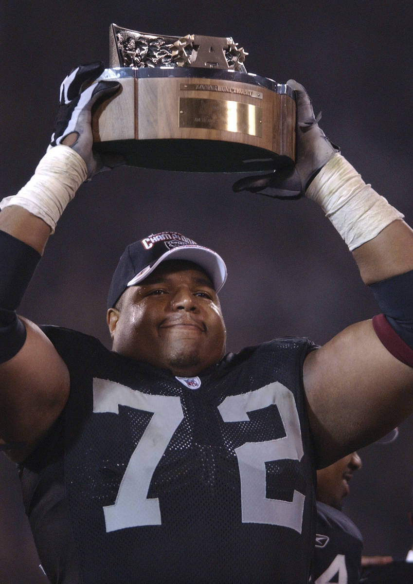 Lincoln Kennedy of the Oakland Raiders holds the Lamar Hunt trophy. The Raiders defeated the Ti ...