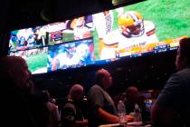 This Sept. 9, 2018 photo shows football fans watching the action on wall-mounted video screens ...