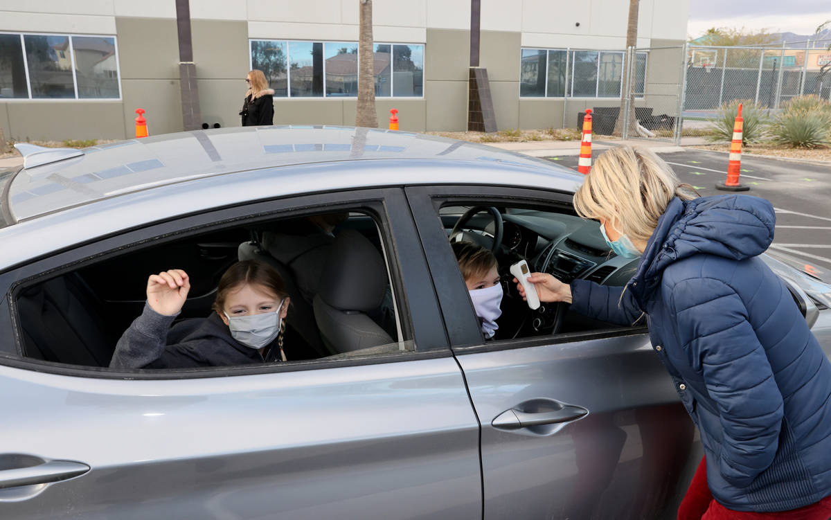 Kim Salerno takes the temperture of Dakota Marx, 7, left, and Connor Nielsen, 8, at the start o ...