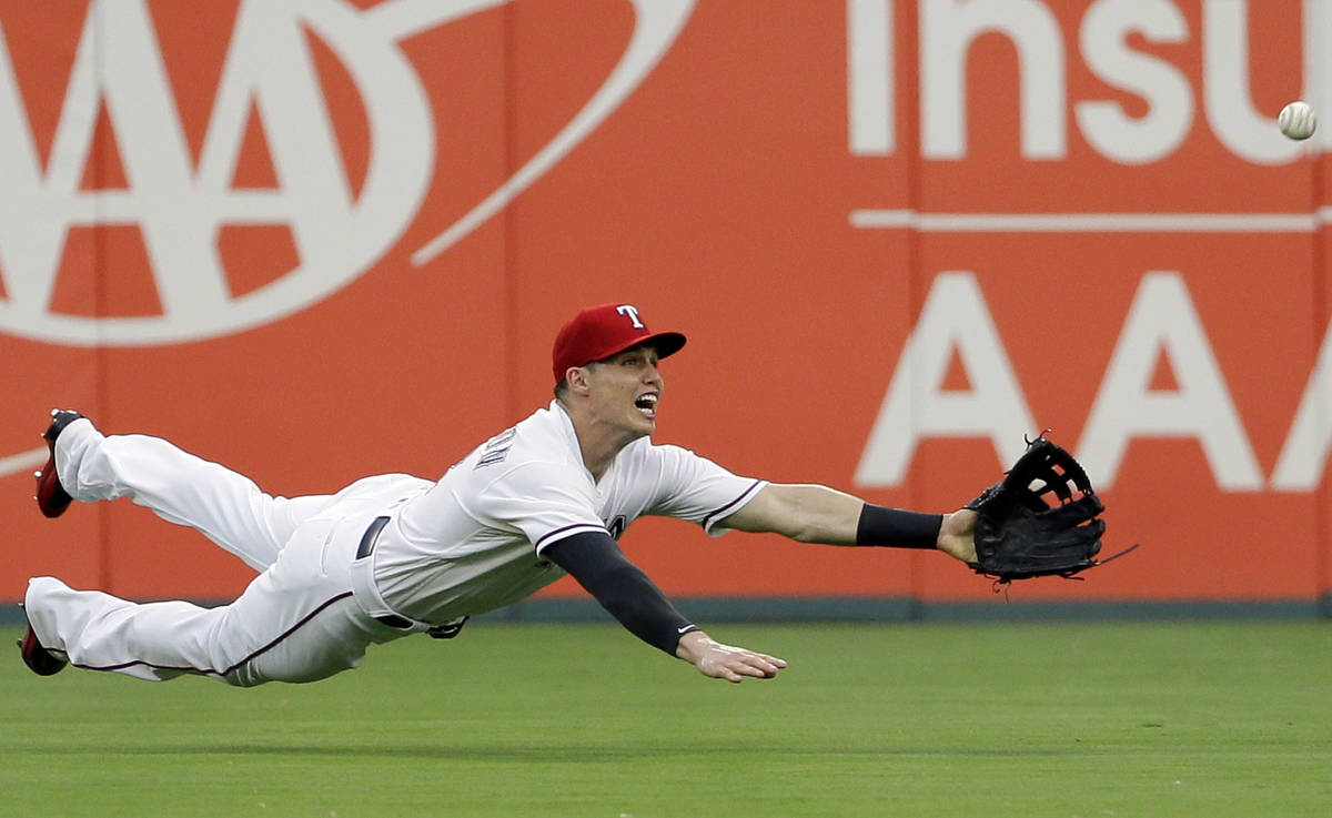Texas Rangers center fielder Drew Robinson leaps to catch a fly-out by Detroit Tigers' John Hic ...