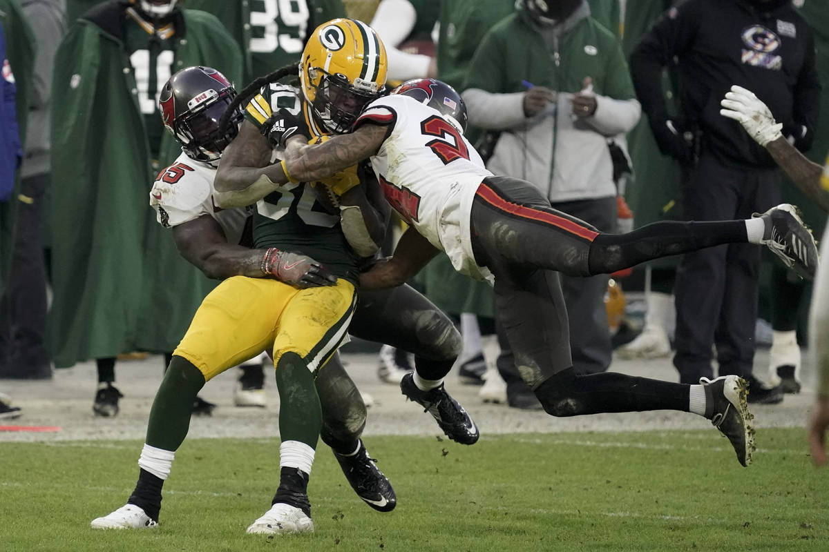 Green Bay Packers' Jamaal Williams is stopped by Tampa Bay Buccaneers' Carlton Davis (24) and D ...