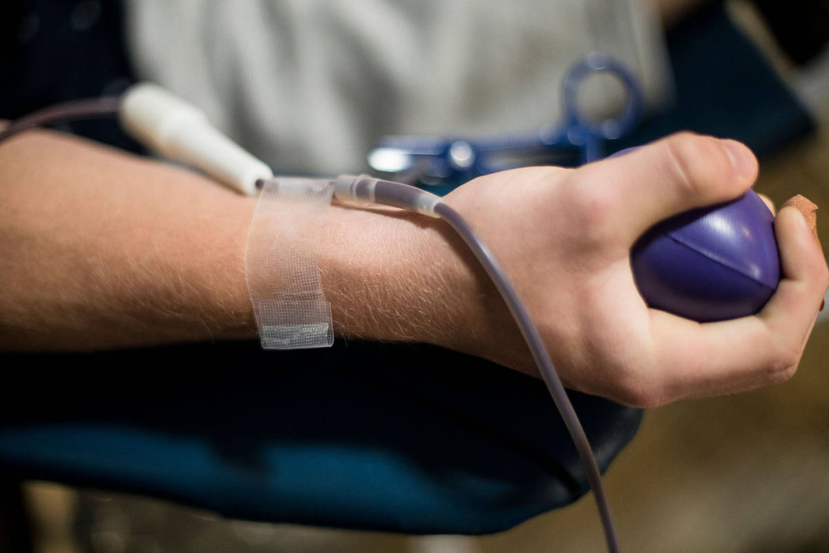 In this April 12, 2020, file photo, William Buening, 17, gives blood at a blood drive hosted by ...