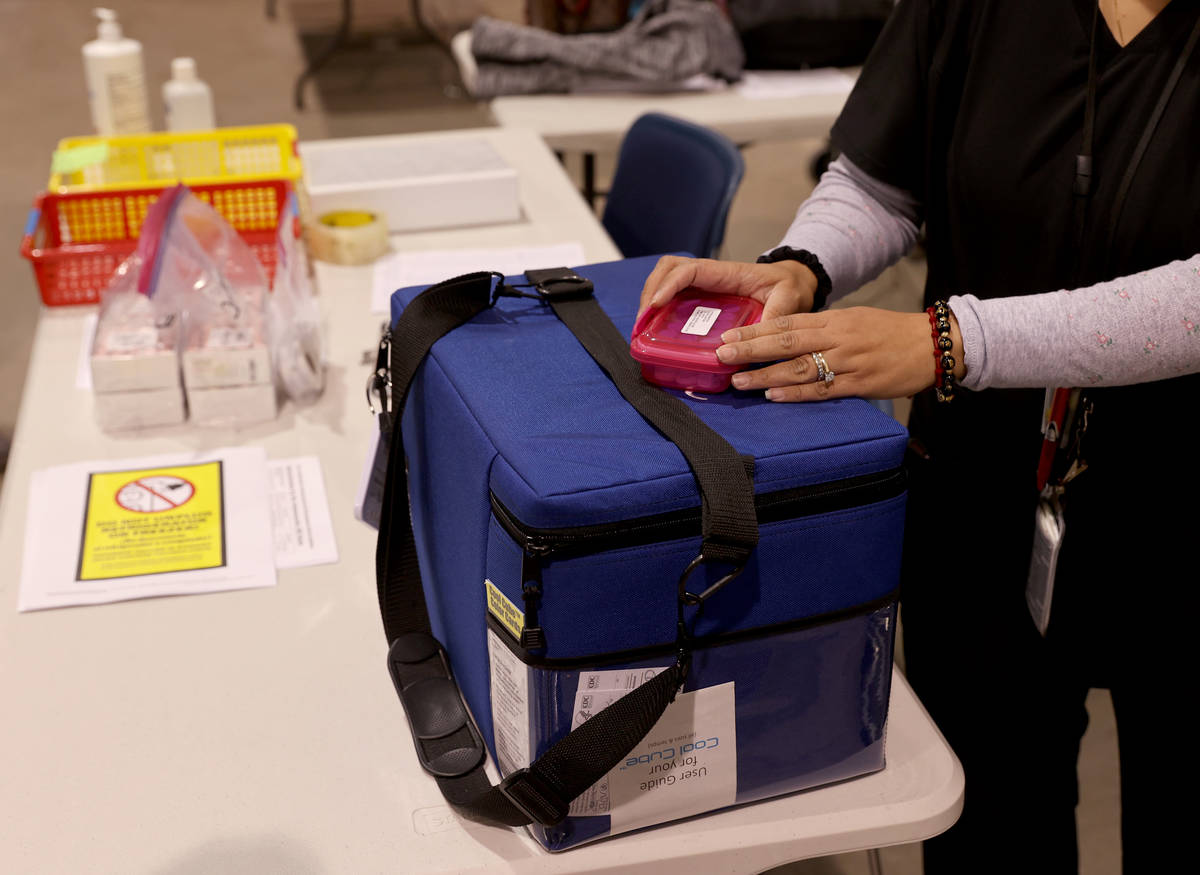 An unidentified worker prepares Pfizer vaccine at the Cashman Center COVID-19 vaccination site ...