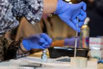 RN Dawn Schuder prepares another dose of the Moderna vaccine at the Southern Nevada Health Dist ...