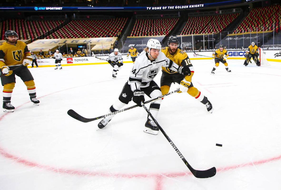 Los Angeles Kings center Lias Andersson (24) and Golden Knights center Nicolas Roy (10) battle ...