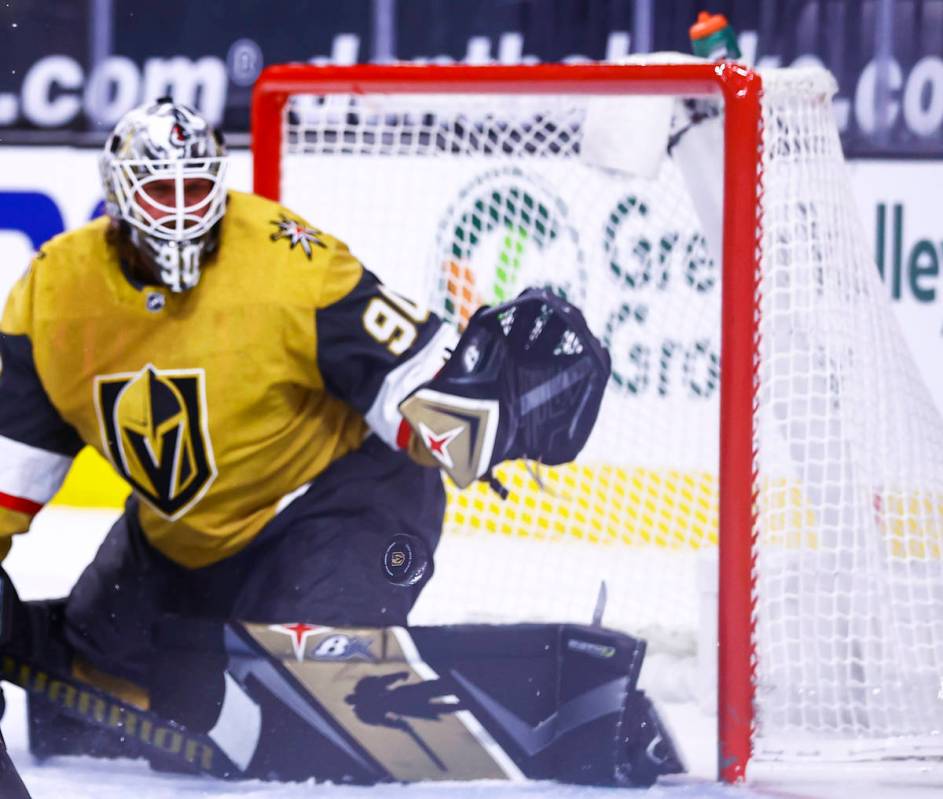 The puck flies past Golden Knights goaltender Robin Lehner (90) during the first period of an N ...