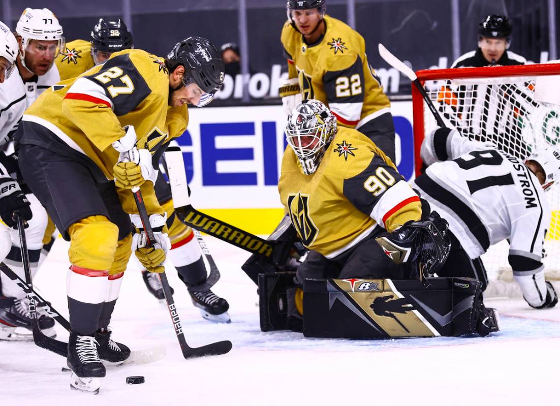 Golden Knights defenseman Shea Theodore (27) keep the puck from the Los Angeles Kings during th ...