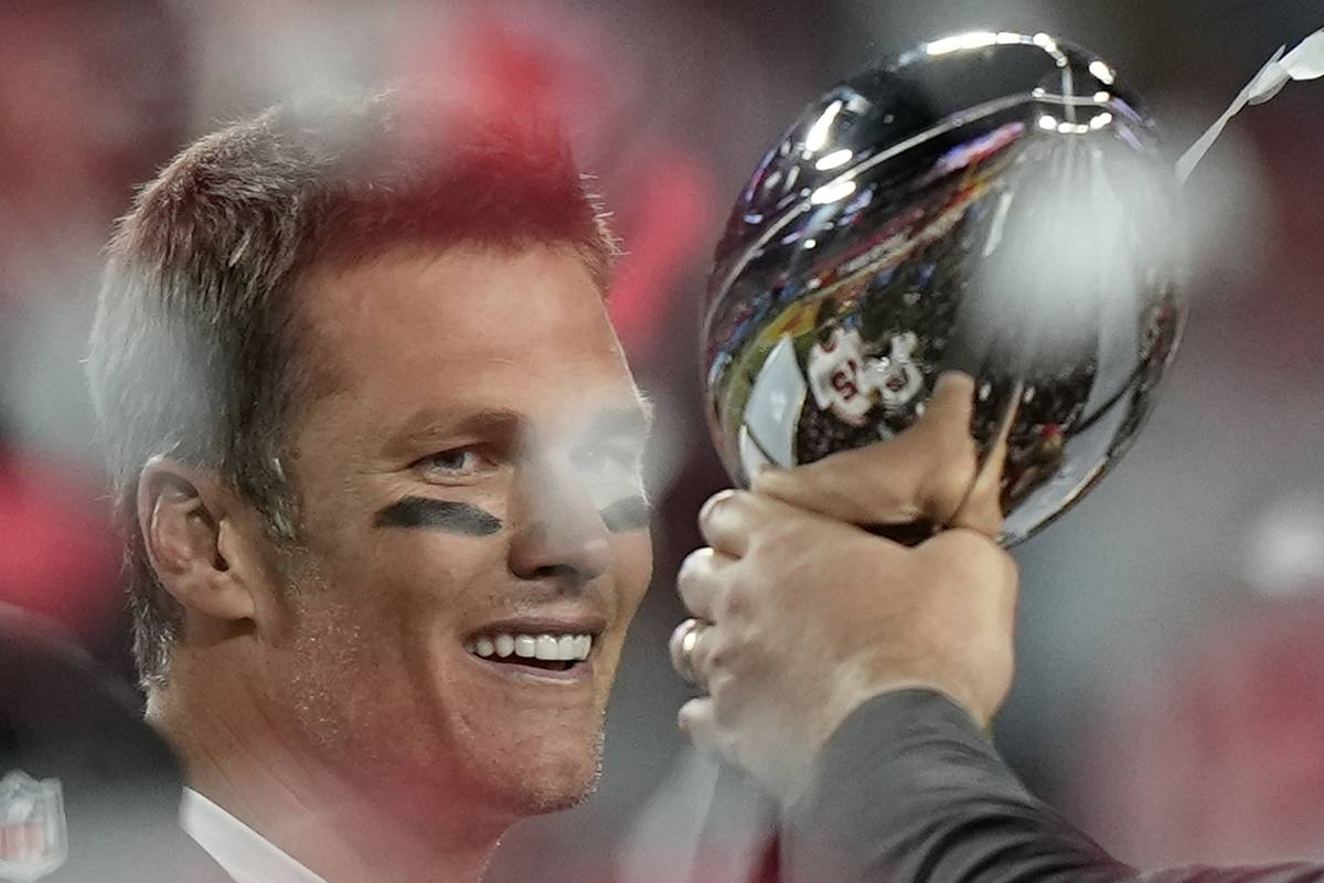 Tampa Bay Buccaneers quarterback Tom Brady looks at the Vince Lombardi trophy after defeating t ...