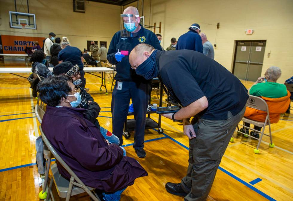 (From right) Sheriff's officer Doug Beasley and Kanawha County EMT Jeff Broyles team up to deli ...