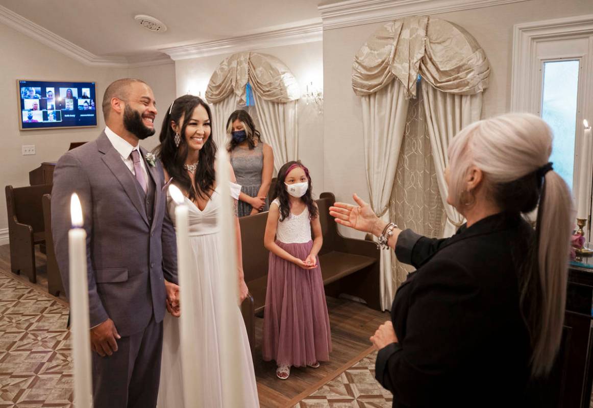 William and Brandi Alexander, from Anchorage, Alaska, listen to their officiant Ginnie Wilson d ...