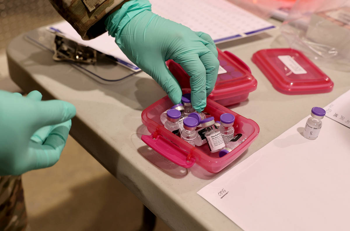 Nevada National Guard Sgt. Candy "D.T." Delatorre prepares Pfizer vaccine at the Cash ...