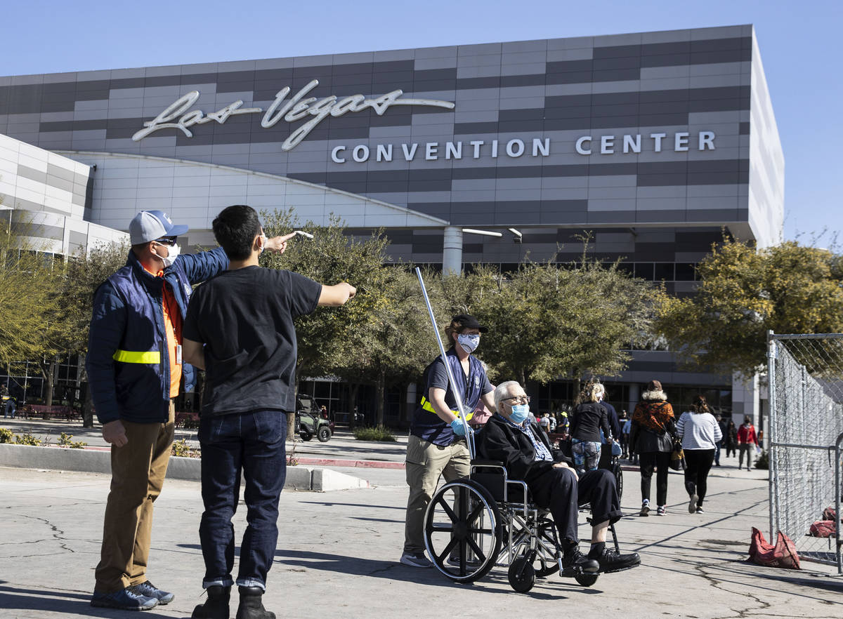 A FEMA employee, who declined to give his name, directs people to the Las Vegas Convention Cent ...