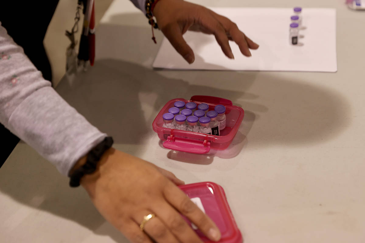 An unidentified worker prepares Pfizer vaccine at the Cashman Center COVID-19 vaccination site ...