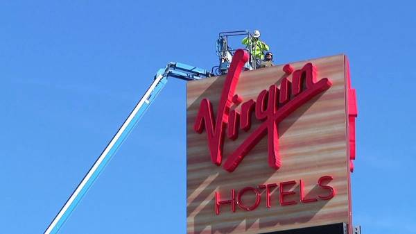 Construction continues as workers are lifted up to a sign on Feb. 11, 2021, at the Virgin Hotel ...