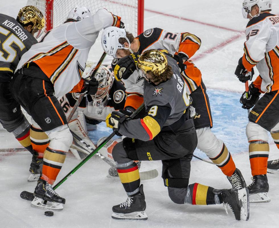 Golden Knights center Cody Glass (9) takes a check from Anaheim Ducks defenseman Jani Hakanpaa ...