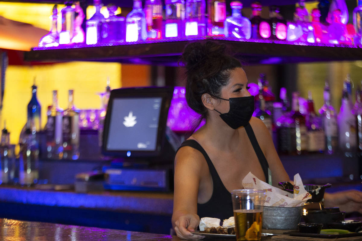 Bartender Elise Gift wears a mask to prevent the spread of coronavirus while working at Nacho D ...