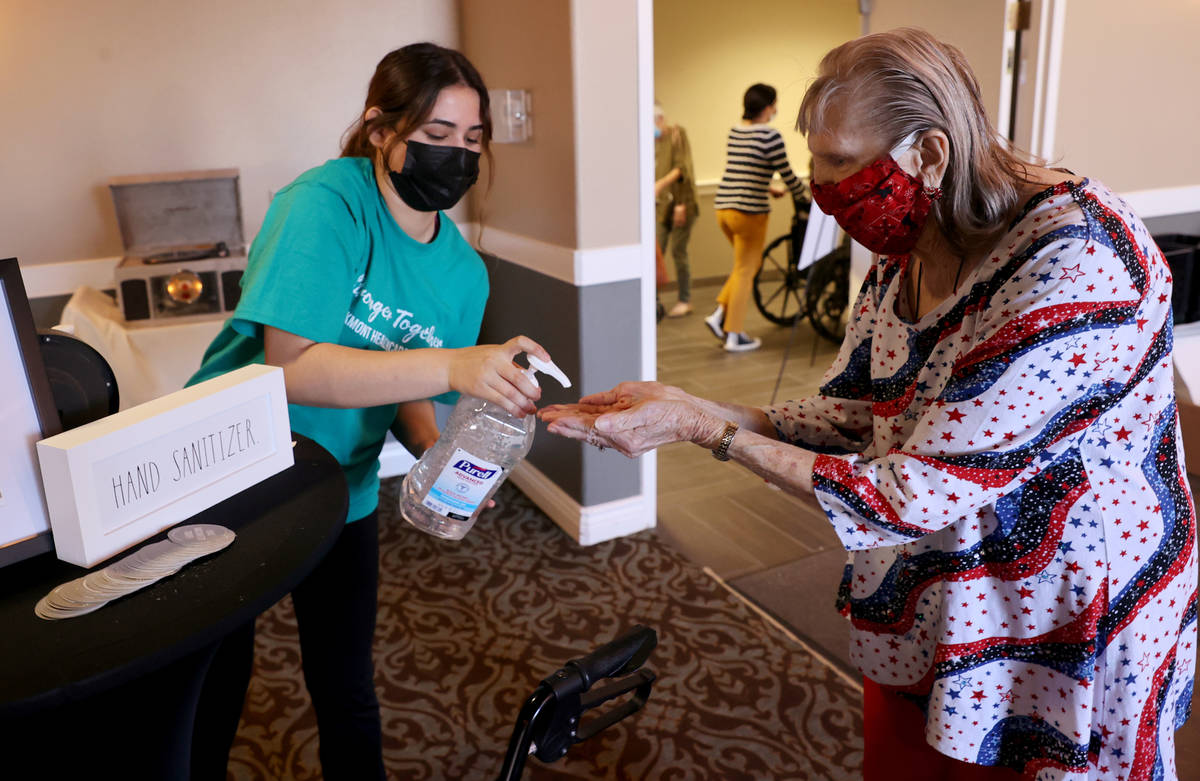 Server Alondra Chavarria gives Beverly Winterboer, 87, hand sanitizer during an in-house COVID- ...