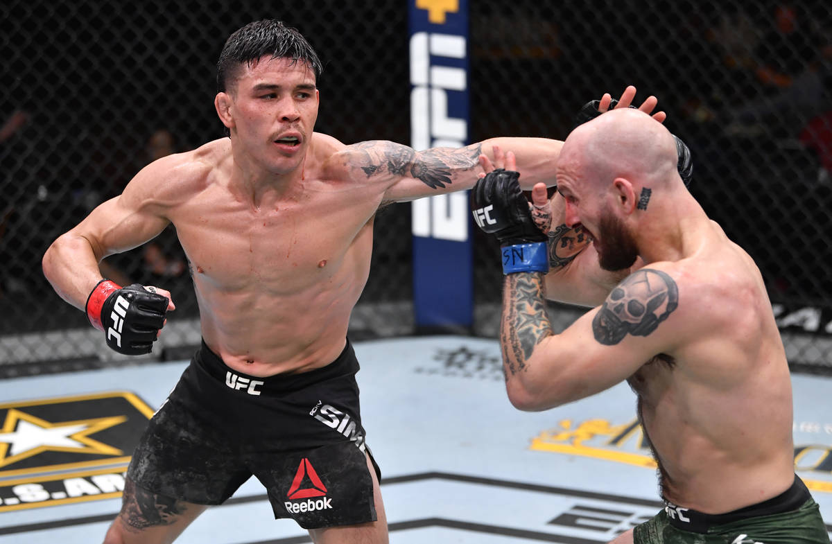 (L-R) Ricky Simon punches Brian Kelleher in their featherweight fight during the UFC 258 event ...