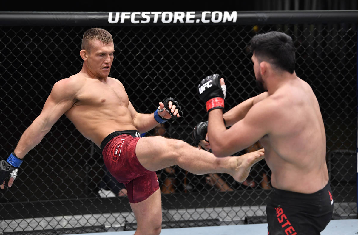 Ian Heinisch kicks Kelvin Gastelum in their middleweight fight during the UFC 258 event at UFC ...