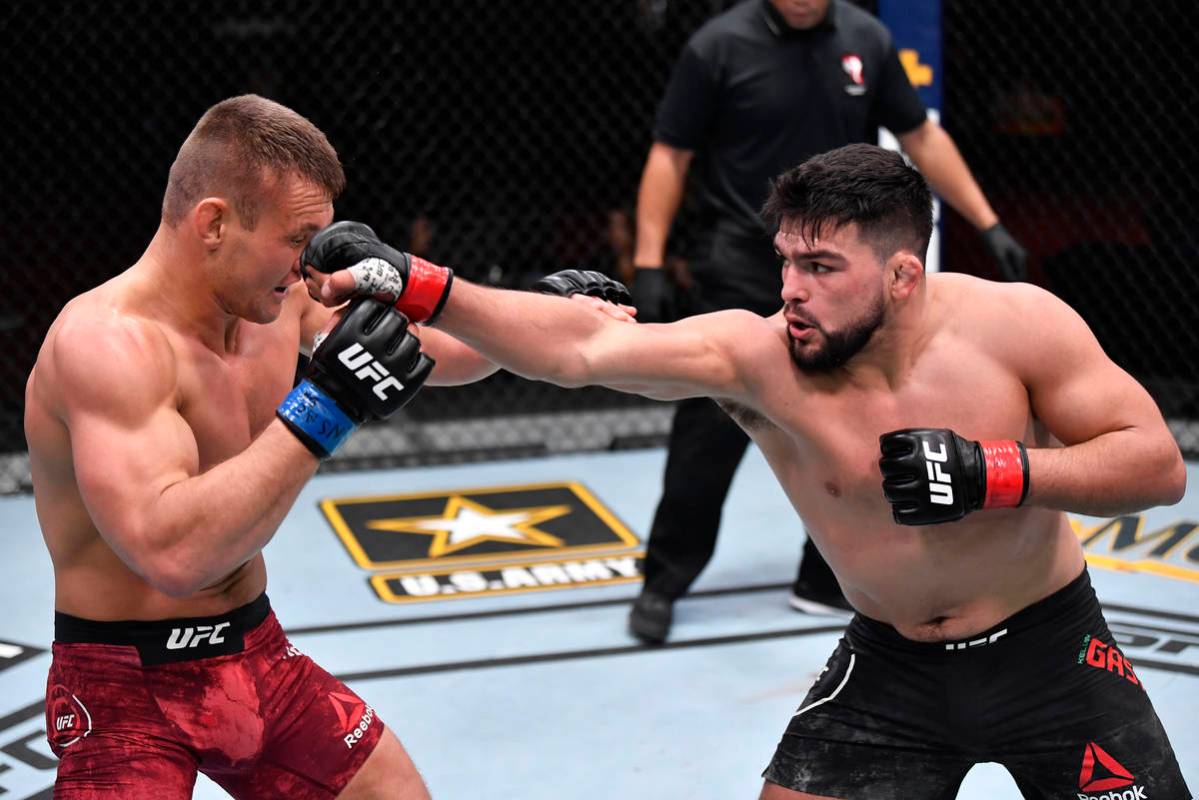 (R-L) Kelvin Gastelum punches Ian Heinisch in their middleweight fight during the UFC 258 event ...