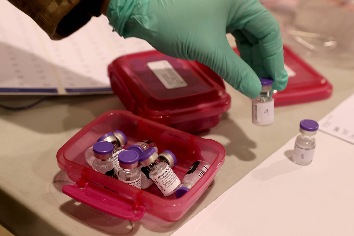 Nevada National Guard Sgt. Candy "D.T." Delatorre prepares Pfizer vaccine at the Cash ...