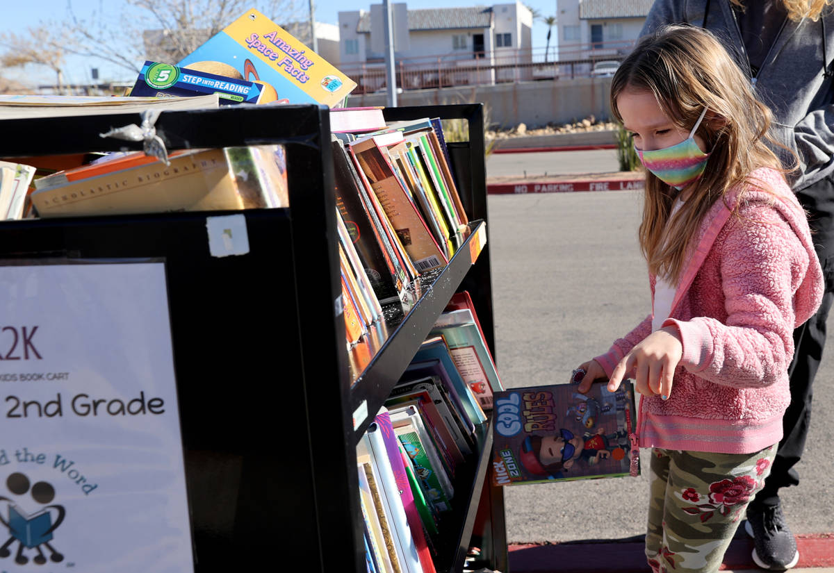 Kindergartner Olive Cantey, 6, chooses books during a school supply distribution event at McCaw ...