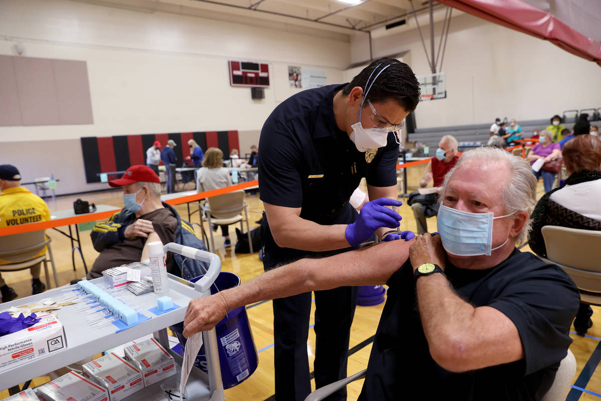Las Vegas Fire Department firefighter Enrique Lopez vaccinates David Belding, 75, of Las Vegas, ...