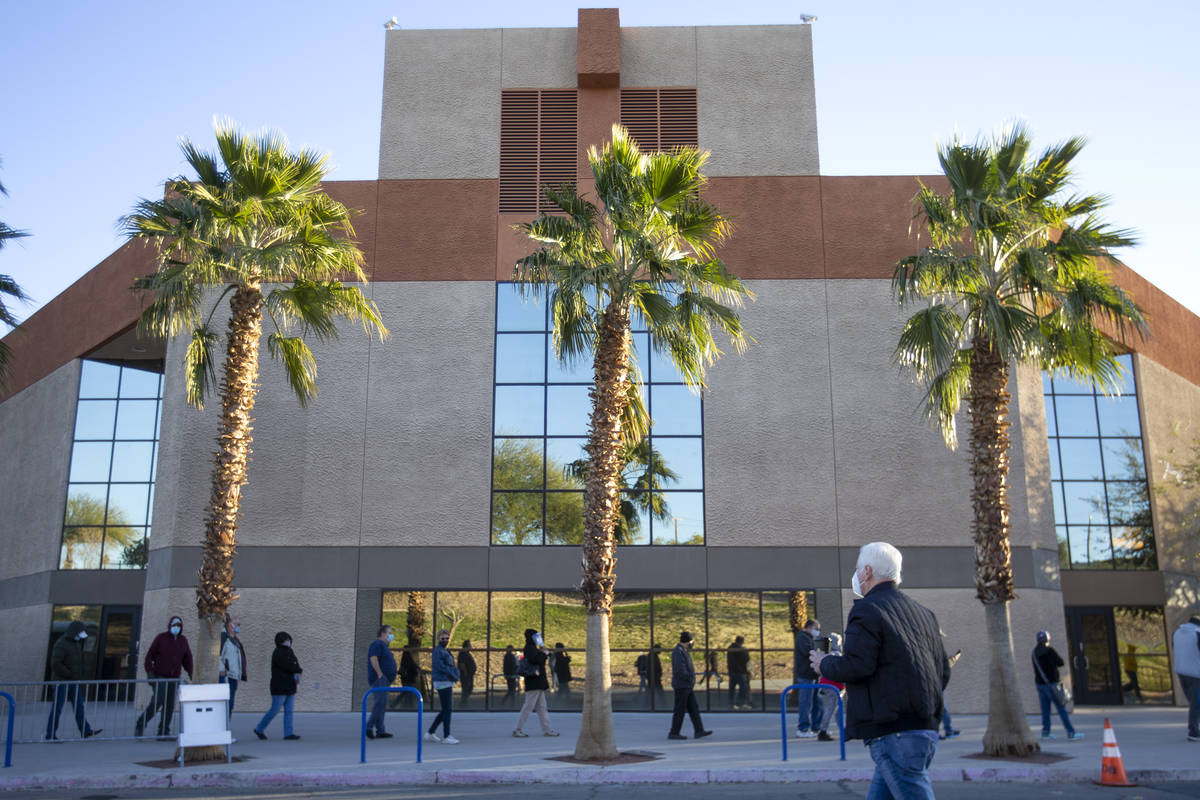 People wait in line for their COVID-19 vaccine at Cashman Field on Saturday, Feb. 20, 2021, in ...