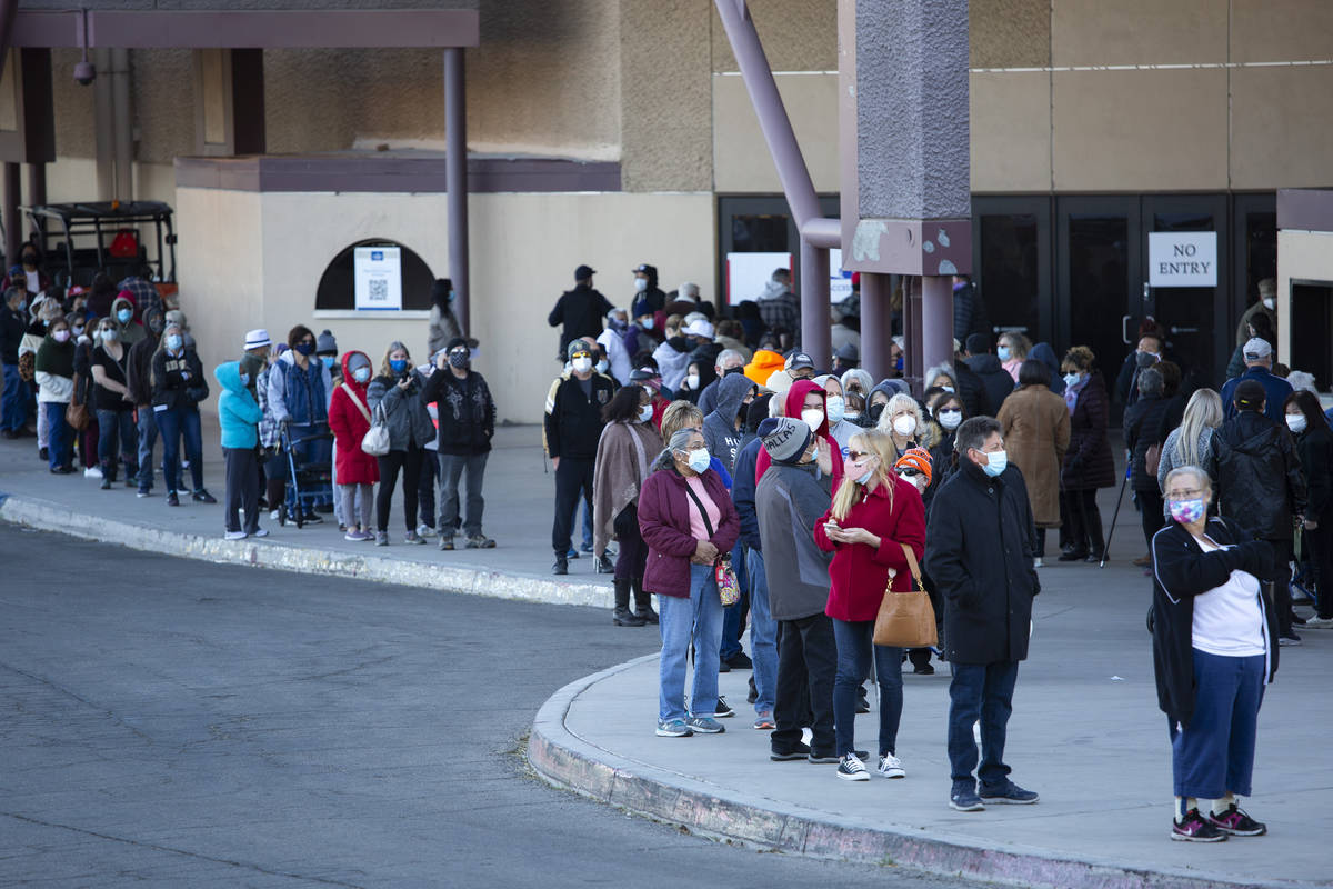 People wait in line for their COVID-19 vaccine at Cashman Field on Saturday, Feb. 20, 2021, in ...