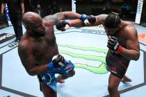 (L-R) Derrick Lewis and Curtis Blaydes trade punches in a heavyweight bout during the UFC Fight ...
