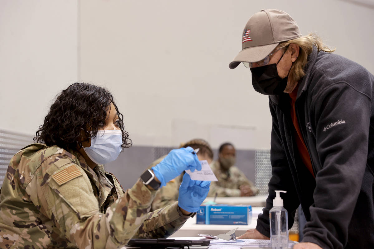 Mike Lucas, 70, of Henderson, checks in with Nevada National Guard Senior Airman Traesha Glover ...