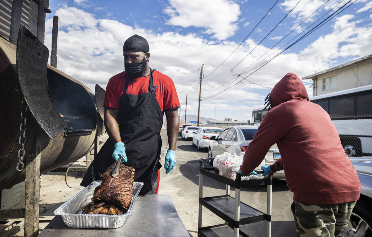 Chef Quincy Reynolds, left, cooks ribs while Jamon Brooks delivers orders to waiting cars at An ...
