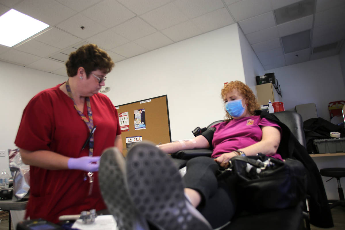 Phlebotomist Eva Clappa,. left, takes a blood donation from Susan Edwards during a blood drive ...