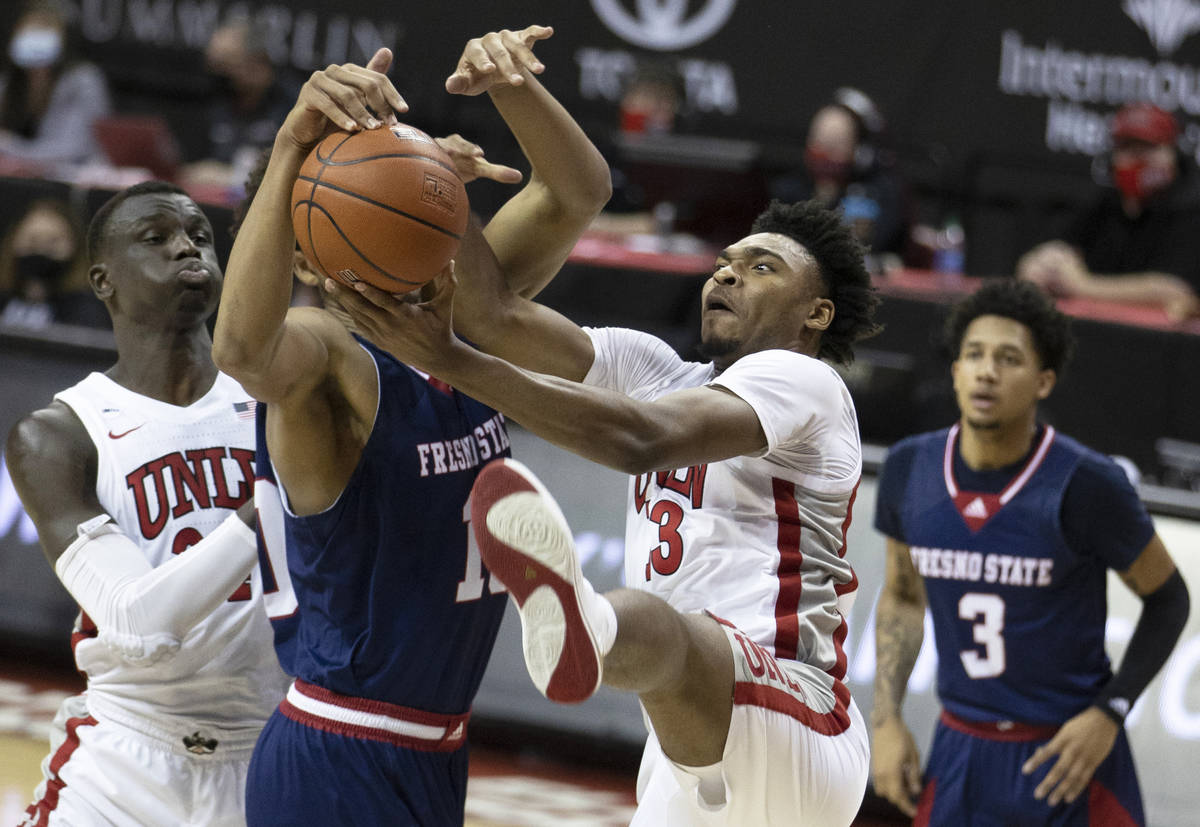 UNLV Rebels guard Bryce Hamilton (13) fight for a loose ball with Fresno State Bulldogs forward ...