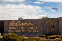 Sign for McCarran International Airport with plane taking off above at Tropicana Avenue and Kov ...