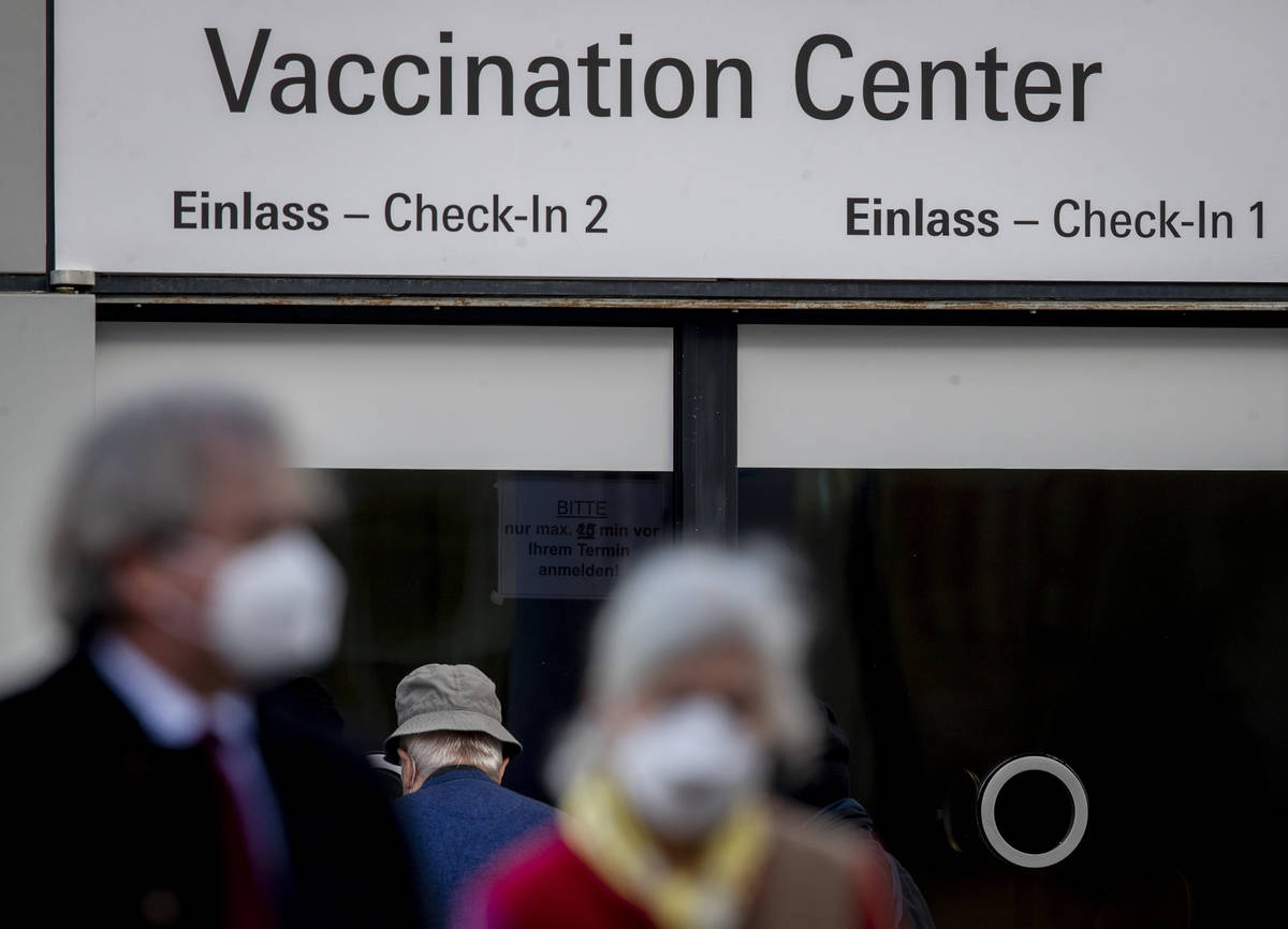 People walk past the entrance of the vaccination center in Frankfurt, Germany, Thursday, Feb. 2 ...
