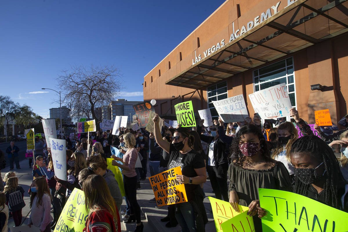 A group of parents, students and folks who want kids back in school protest before outside Las ...